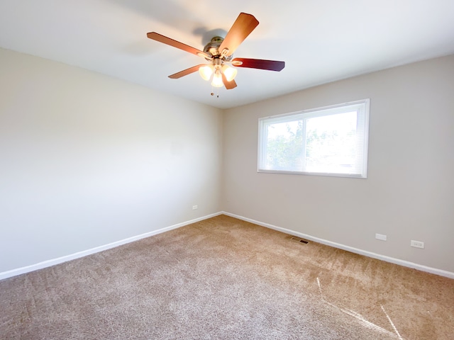 carpeted spare room featuring ceiling fan