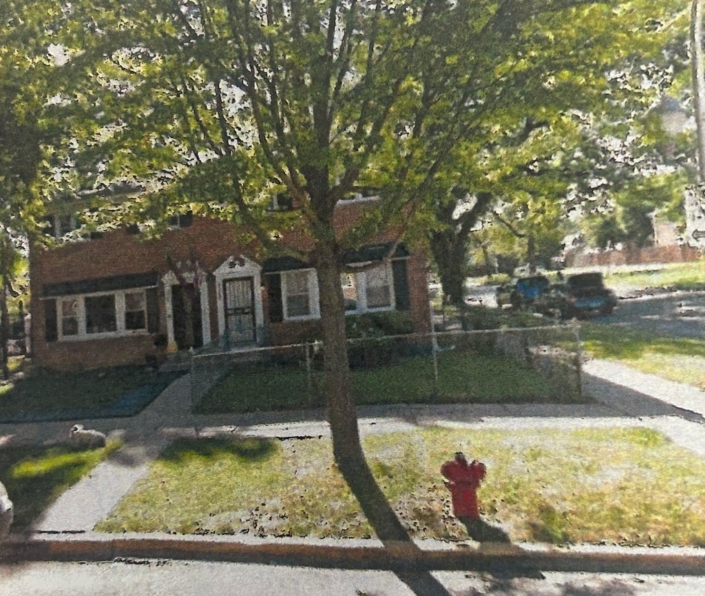 view of property hidden behind natural elements with a front yard