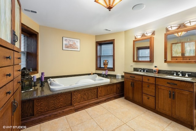 bathroom featuring tile floors, dual vanity, a healthy amount of sunlight, and a tub