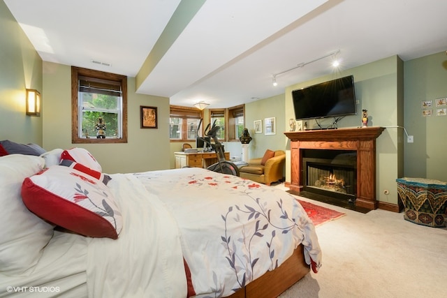 carpeted bedroom featuring track lighting