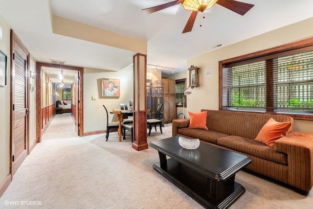 carpeted living room with ceiling fan and rail lighting