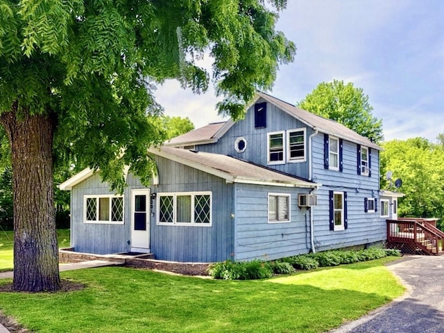 8001 Blivin St, Spring Grove, IL 60081 - view of front facade featuring a front lawn, an AC wall unit, and a wooden deck