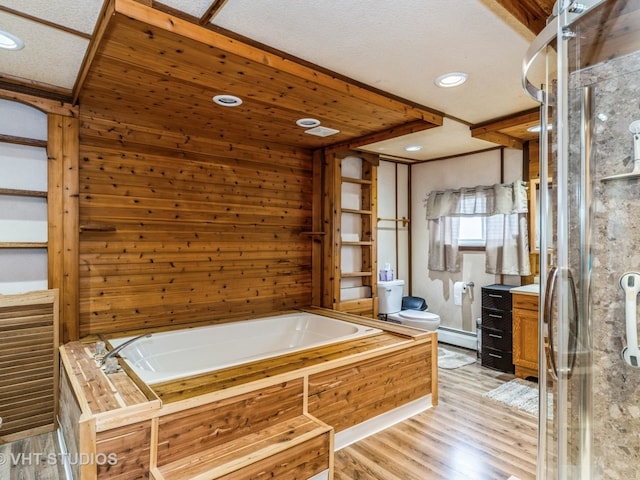 full bath featuring a garden tub, a baseboard radiator, vanity, a shower stall, and wood finished floors