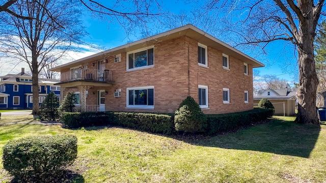 view of side of property with a yard and a balcony