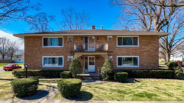 view of front of property featuring a front lawn and a balcony