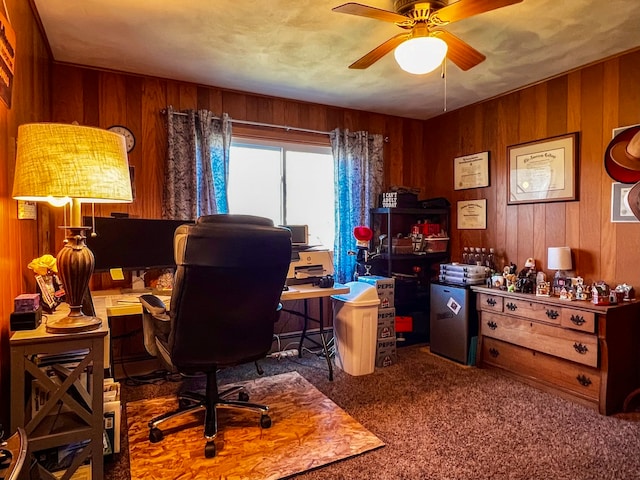 carpeted office space with wooden walls and ceiling fan