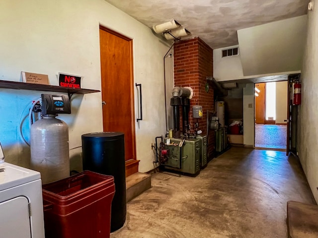 interior space with brick wall, a wood stove, and washer / clothes dryer