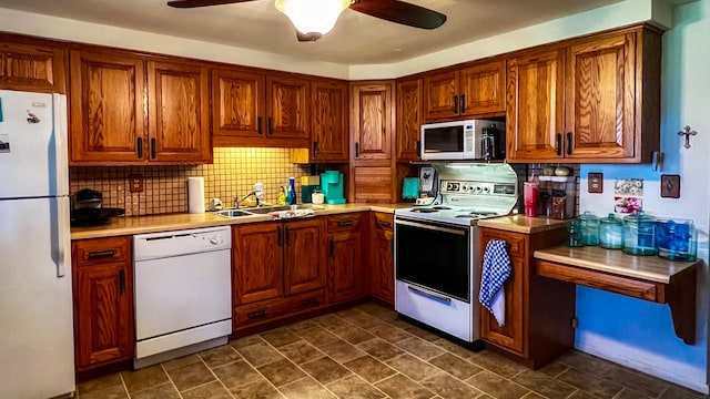 kitchen featuring dark tile floors, white appliances, sink, tasteful backsplash, and ceiling fan