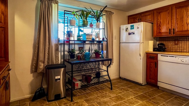 kitchen featuring backsplash, white appliances, and dark tile flooring