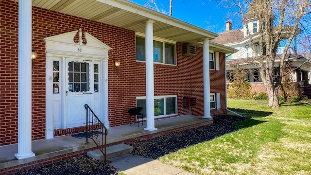 view of exterior entry with a yard