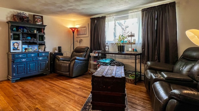 sitting room featuring light hardwood / wood-style flooring and a wall mounted AC