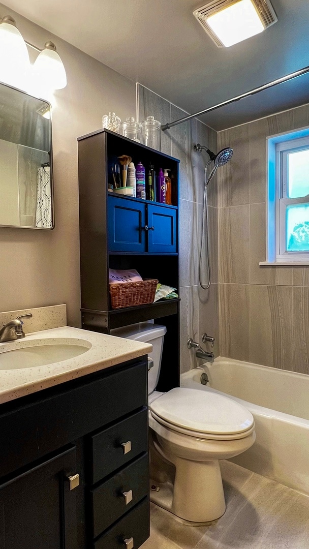 full bathroom with vanity, toilet, tile floors, and tiled shower / bath combo