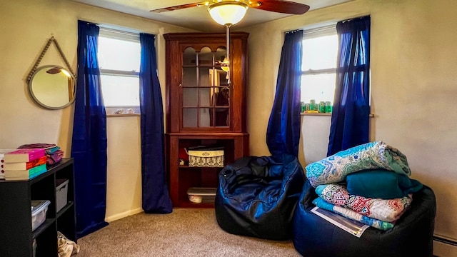 sitting room featuring light colored carpet, a wealth of natural light, ceiling fan, and a baseboard heating unit