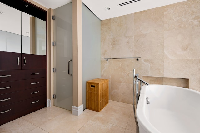 bathroom featuring tile walls, tile flooring, and plus walk in shower