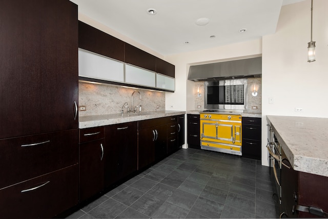 kitchen featuring hanging light fixtures, stainless steel gas cooktop, sink, dark tile flooring, and tasteful backsplash