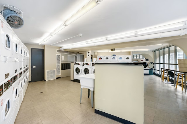 laundry room featuring separate washer and dryer, stacked washer / drying machine, and light tile floors