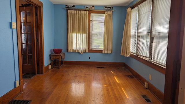 unfurnished room with a healthy amount of sunlight and wood-type flooring