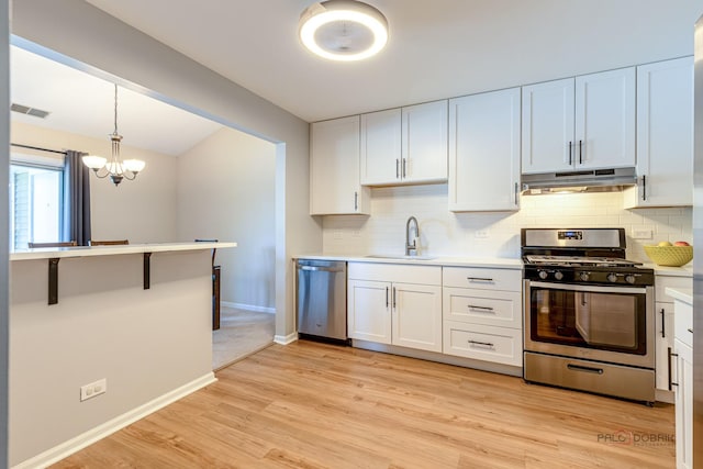 1405 Apricot Ct Unit D, Mount Prospect, IL 60056 - kitchen featuring stainless steel appliances, under cabinet range hood, a sink, backsplash, and vaulted ceiling