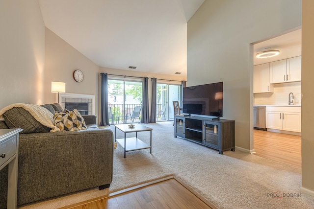 1405 Apricot Ct Unit D, Mount Prospect, IL 60056 - living area featuring a fireplace, light carpet, high vaulted ceiling, light wood-type flooring, and baseboards