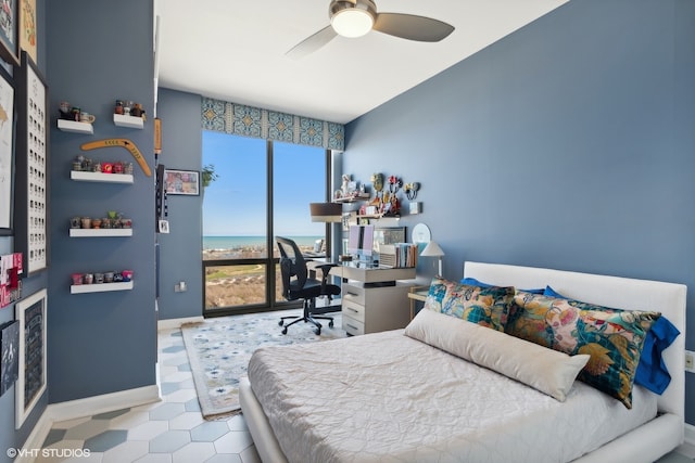 bedroom with a water view, multiple windows, and ceiling fan