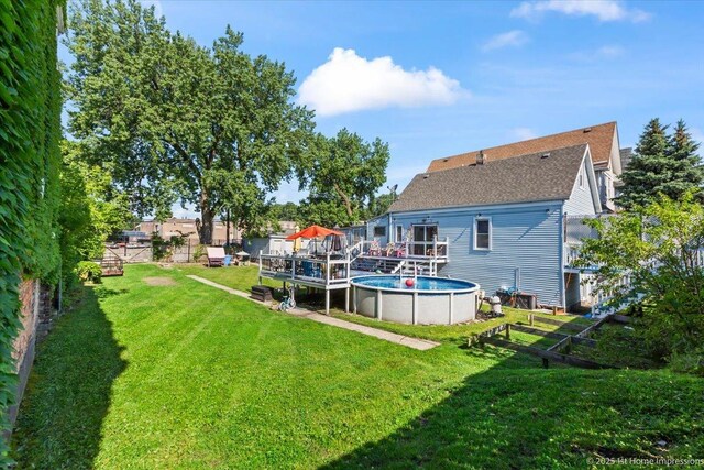 9018 S Brandon Ave, Chicago, IL 60617 - back of house featuring a yard, an outdoor pool, a wooden deck, and a shingled roof