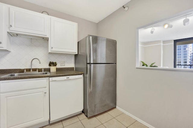 kitchen featuring white cabinetry, dishwasher, sink, stainless steel fridge, and light tile patterned floors