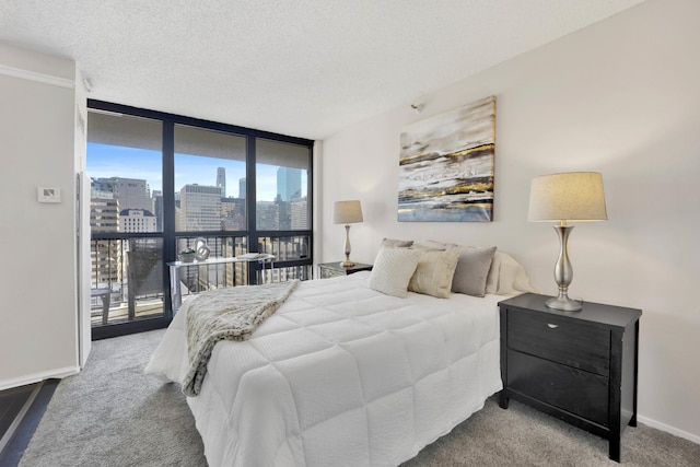 bedroom featuring carpet, floor to ceiling windows, and a textured ceiling