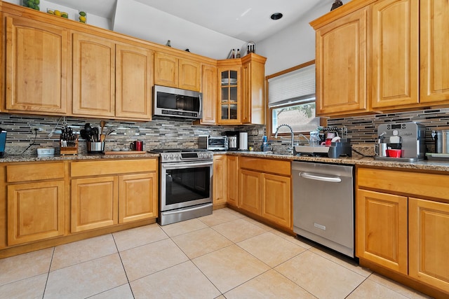 182 Ashley Way, Bloomingdale, IL 60108 - kitchen with stainless steel appliances, backsplash, dark stone counters, light tile patterned floors, and glass insert cabinets