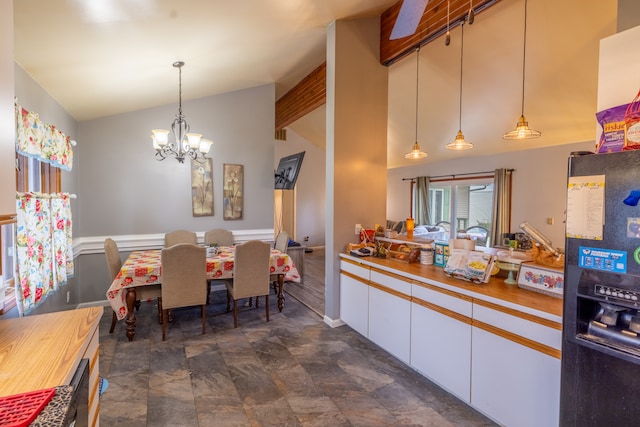 interior space with lofted ceiling with beams, a notable chandelier, and dark tile flooring