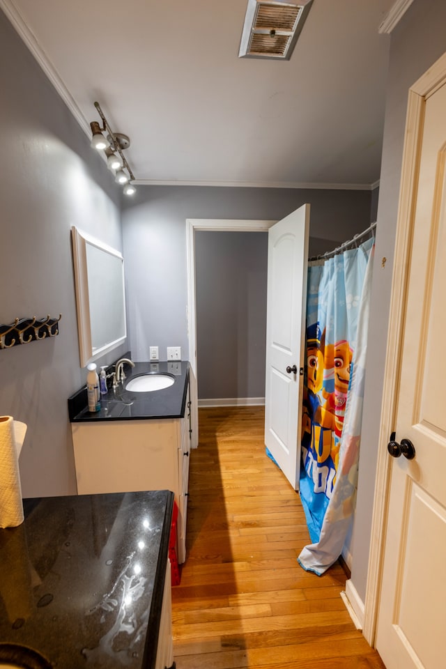 bathroom featuring crown molding, vanity, and hardwood / wood-style flooring