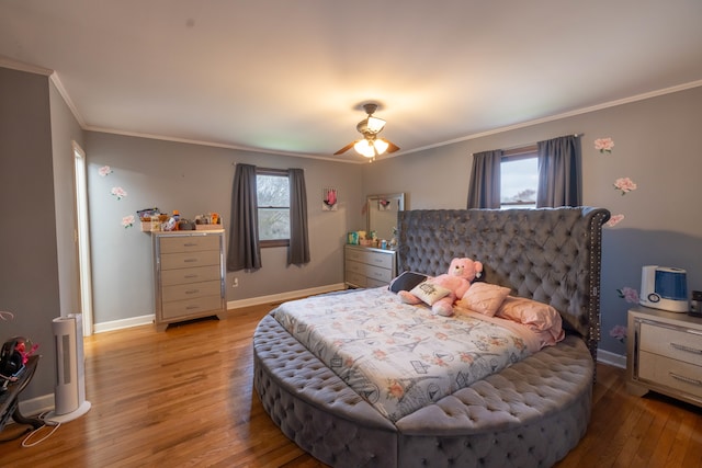 bedroom with ceiling fan, multiple windows, light wood-type flooring, and crown molding