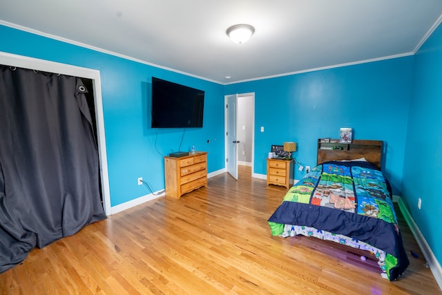 bedroom featuring crown molding and light hardwood / wood-style floors