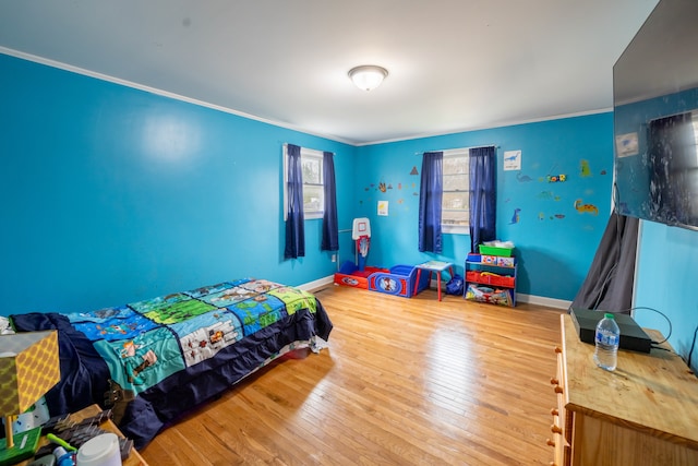 bedroom featuring crown molding and light hardwood / wood-style flooring