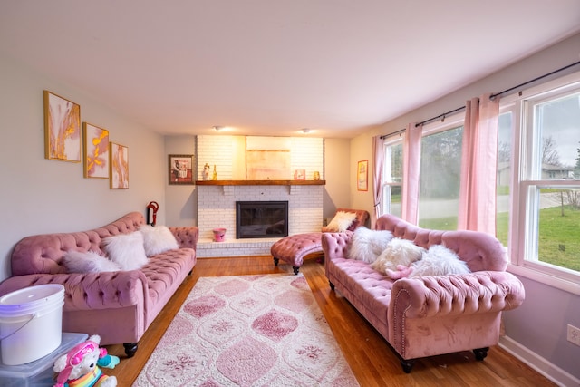 living room with a brick fireplace and wood-type flooring