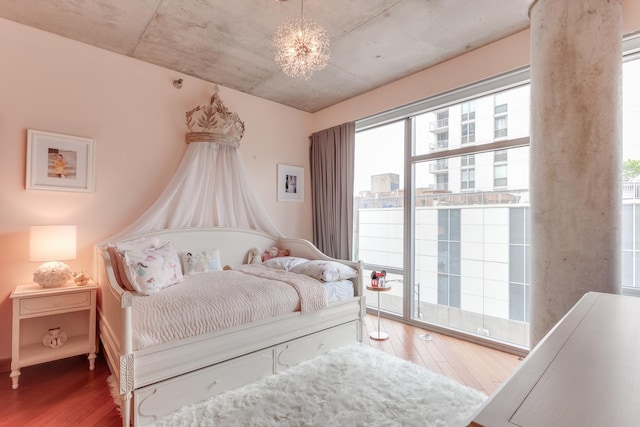 bedroom featuring a chandelier, a view of city, and wood finished floors