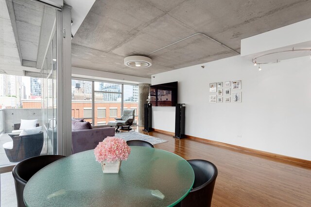 dining space featuring a view of city, wood finished floors, and baseboards