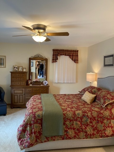 bedroom with light carpet and ceiling fan