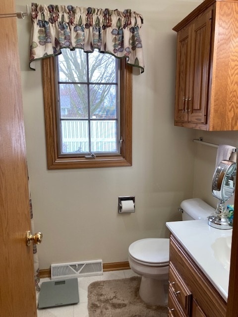 bathroom with vanity, tile floors, and toilet