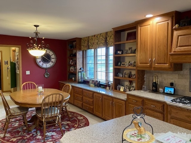 kitchen featuring decorative light fixtures, backsplash, and stainless steel gas stovetop