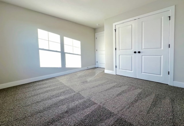 unfurnished bedroom featuring light colored carpet and a closet