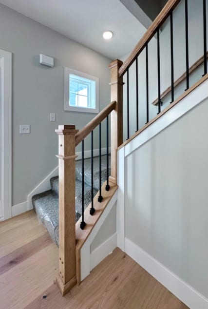 stairway with light hardwood / wood-style flooring