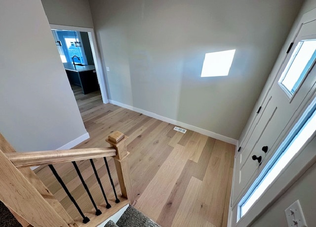 stairs with light hardwood / wood-style flooring