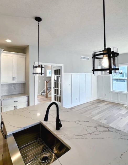 kitchen with decorative light fixtures, white cabinets, a chandelier, and light stone countertops