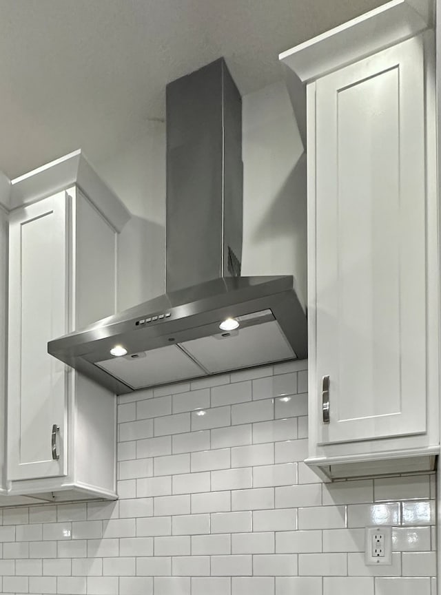 interior details featuring wall chimney range hood