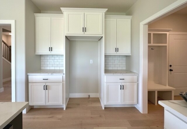 kitchen featuring tasteful backsplash and white cabinets