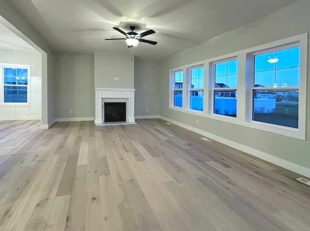 unfurnished living room featuring light hardwood / wood-style flooring and ceiling fan