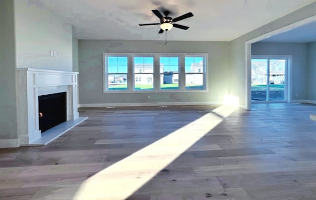 unfurnished living room with dark hardwood / wood-style floors and ceiling fan