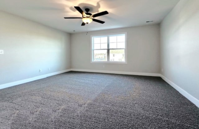 unfurnished room featuring dark carpet and ceiling fan