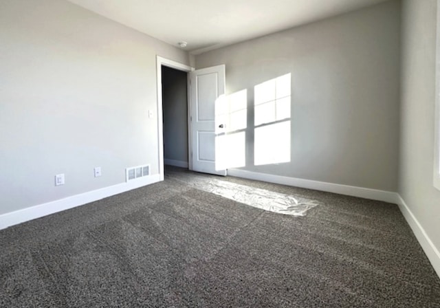 empty room with dark colored carpet