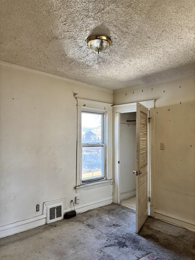 unfurnished bedroom featuring a closet, carpet floors, a textured ceiling, and ornamental molding